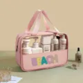 Detailed close-up view of the large capacity pink PVC toiletry bag with colorful BEACH patch - Pink