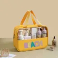 Detail of yellow PVC beach bag with colorful BEACH chenille patches - Yellow