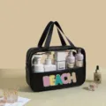 Detail view of the large capacity PVC wash bag with a colorful glitter BEACH patch - Black