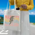 Close-up of MAMA LIFE printed canvas tote bag shown in a sunny outdoor lifestyle setting - Style 9