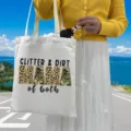 Close-up of the Glitter & Dirt Mama leopard print canvas tote bag held by a model - Style 8