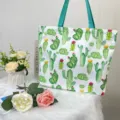 Detailed view of large capacity tote bag featuring vibrant cactus prints and blue straps. - Cactus