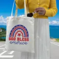 Close-up of patriotic God Bless America rainbow print on white canvas tote bag - Style 6