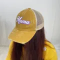 Close-up of mustard yellow distressed trucker hat with purple Mama print - Yellow