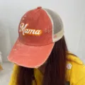 Close-up detail of distressed orange mesh baseball cap featuring Mama print design - Orange