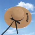 Detail view of woven straw sun hat with black ribbon bow and Cherry embroidery - One Size / Khaki