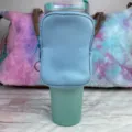 Detail view showing a blue neoprene accessory pouch securely attached to a 40oz tumbler - Sky Blue