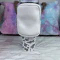 Detail view of a white neoprene pouch attached to a 40oz tumbler with cow print - White