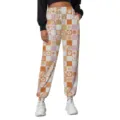 Detail view of orange checkered sweatpants with vintage smile, sun and rainbow motifs - Checkered Style