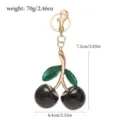 Detailed view of the sparkling cherry keychain showing 7.2cm height and 6.4cm width dimensions. - Black Glitter