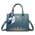 Dark teal leather shoulder handbag with silk scarf decoration, golden embroidery and metal logo. - Blue