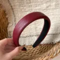 Closeup of a burgundy crocodile pattern wide padded headband, vintage retro hair hoop detail. - Burgundy