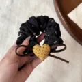 Detail shot of black floral scrunchie with cute brown bow and yellow polka dot heart charm. - Black Floral Yellow Heart