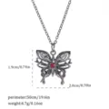 Macro view of gothic black butterfly necklace pendant with red gem and size measurements - Hollow Butterfly