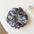 Vue en gros plan de chouchou en satin à motif léopard bleu avec bordure marron. - Chouchou Léopard Bleu Double Couche