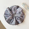 Vue détaillée de l'élastique à cheveux léopard bleu clair avec bordure volantée marron. - Chouchou Léopard Bleu Simple Couche