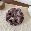 Detailed shot of a luxurious dark mauve satin hair scrunchie with layered ruffles. - Four Layer Waist Scrunchie / Grey Purple