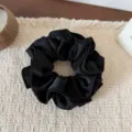 Detailed close-up view of the elegant black satin ruffled hair scrunchie displaying soft texture. - Four Layer Waist Scrunchie / Black