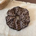Close-up detail of a large retro leopard print hair scrunchie with ruffled black trim. - Large Single Layer Style