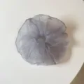 Primer plano detallado de un coletero esponjoso y transparente con lunares para el cabello. - Lunares morados