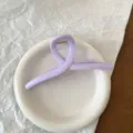 Primo piano dettagliato di un elegante fermaglio per capelli in acrilico viola chiaro - Stile Incrociato Viola