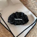 Detailaufnahme der schwarzen Stoff Haarklammer mit weißen Punkten und elegantem Perlenbesatz. - Schwarze Punkte