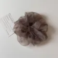 Vue rapprochée d'un chouchou en organza dégradé gris foncé avec une texture scintillante. - Chouchou / Brun Étoilé
