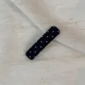 Close-up detail of a classic black polka dot hair clip, showing the fabric texture clearly. - Rectangular Clip / Black