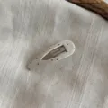 Primer plano detalle de la horquilla BB de tela de lunares con textura y broche metálico. - Blanco Crema-Horquilla Clic Clac Gota