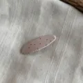 Vista detallada de pinza para el cabello de tela con lunares, superficie beige con puntos negros. - Rosa-Horquilla Clic Clac Ovalada