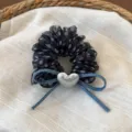 Dettaglio in primo piano dell'elastico per capelli in rete nera a pois con fiocco in denim. - Pois Neri