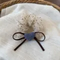 Primo piano dettagliato di un grazioso scrunchie in tulle con cuore a quadri e fiocco. - Pois Bianco Sporco
