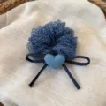 Primo piano dettaglio di elastico per capelli a quadretti blu con fiocco in denim delicato. - Quadretti Blu