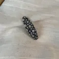 Close-up detail of a Korean pastoral floral fabric oval snap hair clip with blue flowers. - Oval Clip / Blue Floral