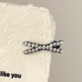 Close-up detail of a sparkling rhinestone cross hair clip on textured paper background. - Cross Hairpin - Clear Rhinestone