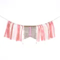Close-up of pink and white ribbon high chair banner for girl's first birthday party. - Dusty Pink