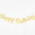 Macro view of the shiny golden Happy Birthday script banner for party decoration - Gold Happy Birthday Banner