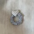 Gedetailleerd overzicht van de grijze satijnen haarring met een schattig zwart-wit hart. - Scrunchie / Wit