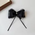 Close-up of elegant black lace bow hair clip with delicate pearl accent and mesh details. - Spring Clips / Black