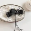 Detail view of a sweet black denim bow hair banana clip featuring long ribbons and crystal. - 13cm / Black