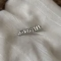 Nahaufnahme der silbernen metallischen Wellen-Haarspange mit feiner Textur und Glanz. - Gefaltete Welle (Helles Silber)