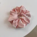 Elegante roze saten haarscrunchie met glanzende afwerking, perfect voor stijlvolle dagelijkse looks. - Roze