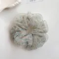 Close-up detail of the floral organza hair scrunchie, showing soft fabric and delicate print. - Green Rhinestone Floral
