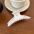 Pinza de pelo de acetato blanco con patrón de mármol, detalle elegante sobre madera. - Estilo Largo Curvo