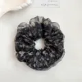 Detail view of a black floral organza hair scrunchie with rhinestones, fluffy and stylish. - Black Rhinestone Floral