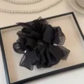 Gros plan détail du chouchou en filet noir avec perles délicates et ruban nœud. - Noir