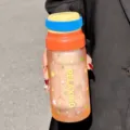 Vue détaillée de la bouteille d'eau en verre givré portable avec une poignée en silicone. - 650ml / Orange (GP-4175)