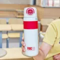Detailansicht der weiß-roten Thermosflasche in der Hand, zeigt tragbares Design. - 680ML / Rot