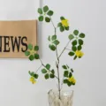 Artificial plant vine with small yellow flowers and green leaves in glass vase for home decor. - Short Branch / Yellow