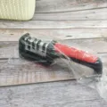 Close-up detail of the manual multi-stage knife sharpener with ergonomic red handle. - 4-Stage